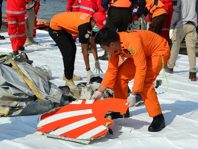 Rescue team members arrange the wreckage, showing part of the logo of Lion Air flight JT610