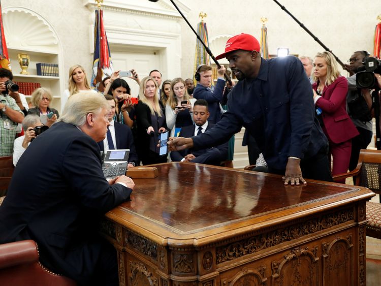 Kanye West shows Donald Trump his mobile phone in the Oval Office