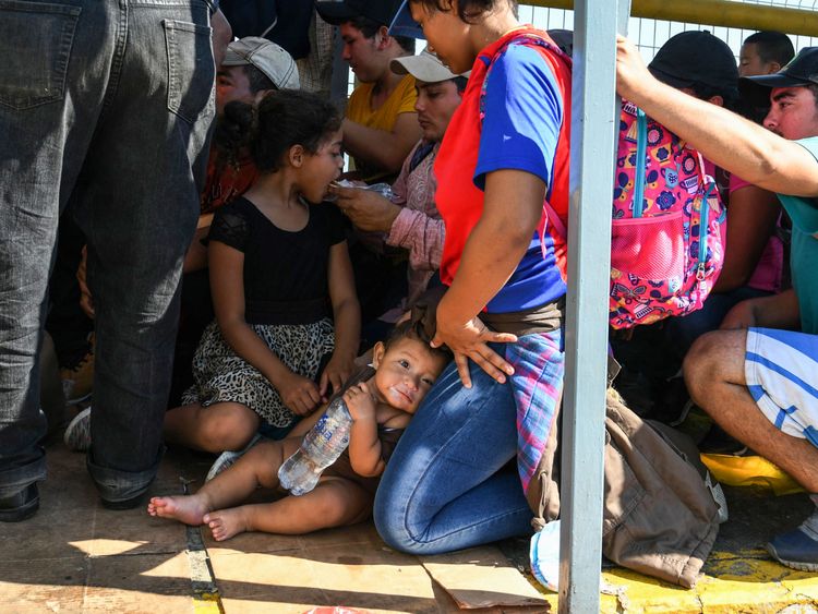 Honduran migrants wait to cross the border from Ciudad Tecun Uman, Guatemala, to Ciudad Hidalgo, Mexico