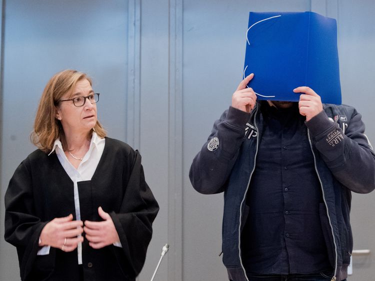 Former nurse Niels Hoegel covers his face as he arrives for the start of his trial in a courtroom in Oldenburg, Germany, October 30, 2018. Julian Stratenschulte/Pool via REUTERS