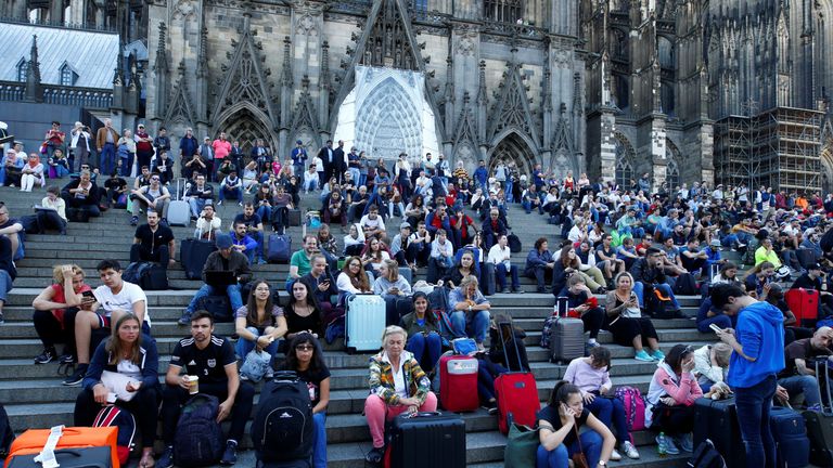 Passengers wait outside the main train station in Cologne, Germany