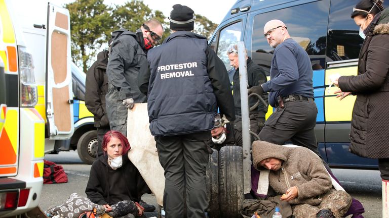 Police had to cut two people free after they apparently cemented their arms into stacks of tyres