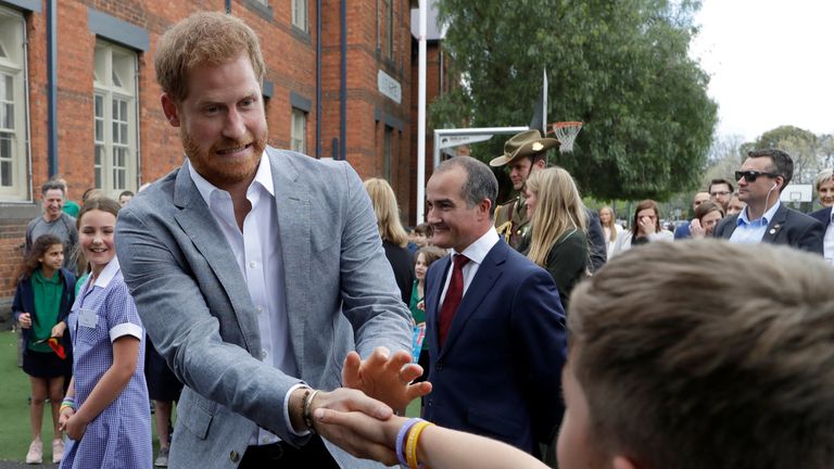 Prince Harry shakes hands with a pupil during a visit to Albert Park Primary School in Melbourne