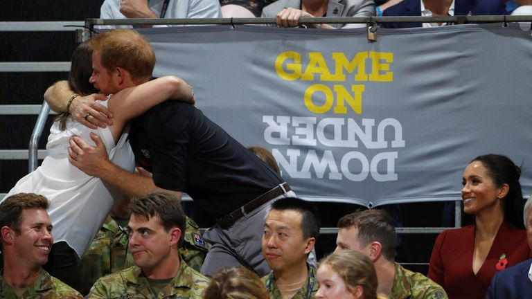 Britain's Prince Harry hugs a spectator as Meghan, Duchess of Sussex, looks on during the Invictus Games Sydney 2018 wheelchair basketball gold medal match at Quaycentre in Sydney, Australia October 27, 2018