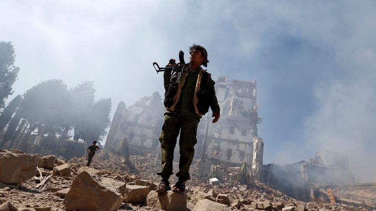 A Houthi rebel inspects damage caused after an airstrike reportedly carried out by the Saudi-led coalition
