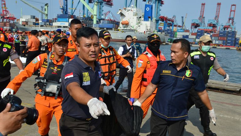 Rescue team members carry a body bag with the remains of a passenger of Lion Air flight 