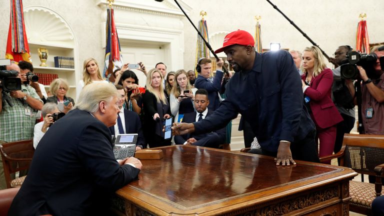 Kanye West shows Donald Trump his mobile phone in the Oval Office