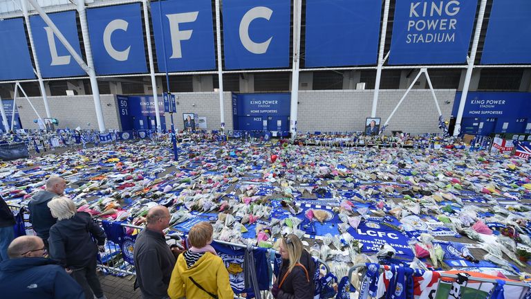 People pause at the tributes gathered outside Leicester City Football Club&#39;s King Power Stadium in Leicester, eastern England, on October 31, 2018