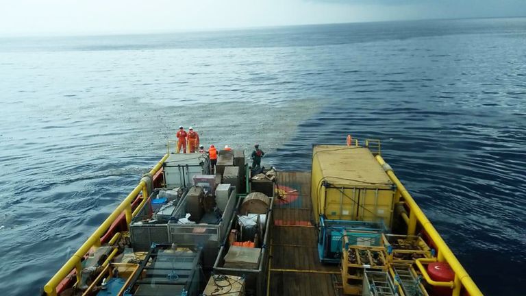Workers on a ship look at what is believed to be debris from crashed Lion Air flight