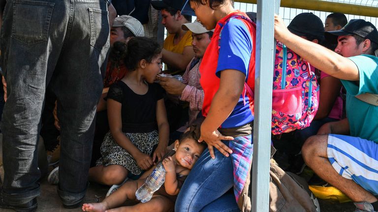 Honduran migrants wait to cross the border from Ciudad Tecun Uman, Guatemala, to Ciudad Hidalgo, Mexico