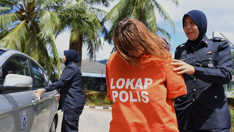 British national Samantha Jones is escorted by a police officer as she arrives at a court in Langkawi 
