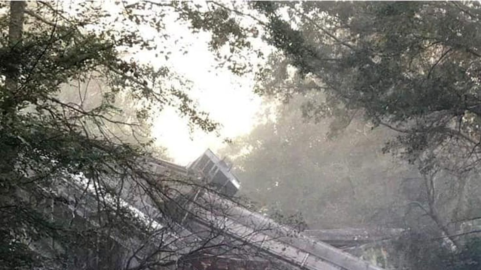 Dozens of carriages fall on to highway after train derails in