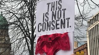 A protester at Belfast City Hall highlights concerns over how rape trials are conducted in Ireland