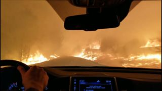 Dramatic footage of family driving through wind driven fire in Paradise, California as thousands of people are urged to flee.