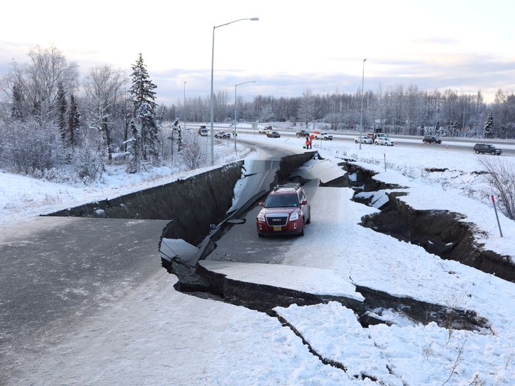 A stranded vehicle lies on a collapsed roadway near the airport after an earthquake in Anchorage