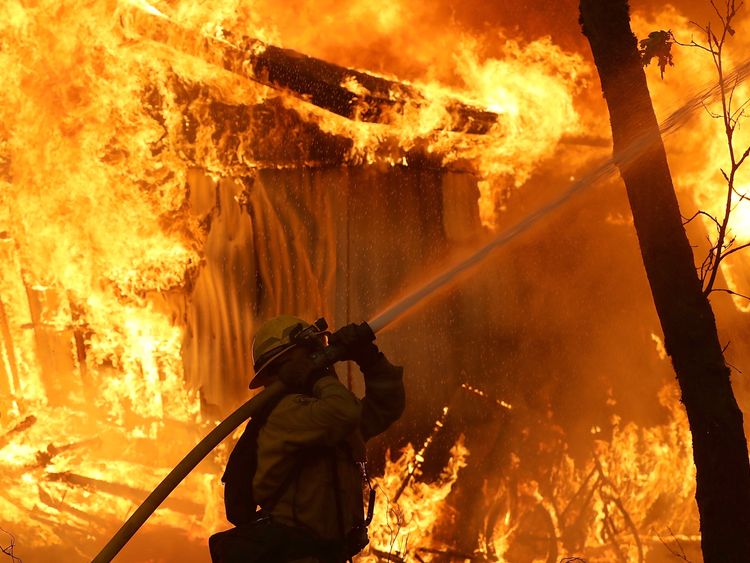 A firefighter battles a wild fire blaze in Magalia, California
