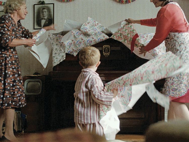 Elton unwraps his present with his mother and grandmother