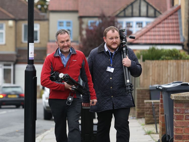 Police investigators arrive outside a house being searched in connection with the video