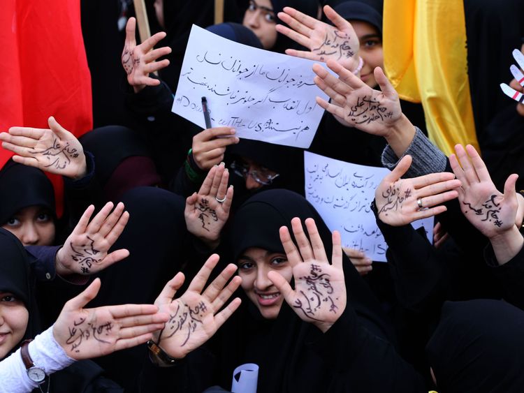Iranian girls take part in the demonstration writing on their palms praising the Ayatollah Khamenei