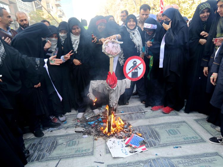 Iranian protesters burn an effigy of the US president placed on huge prints of US 100 dollar banknote