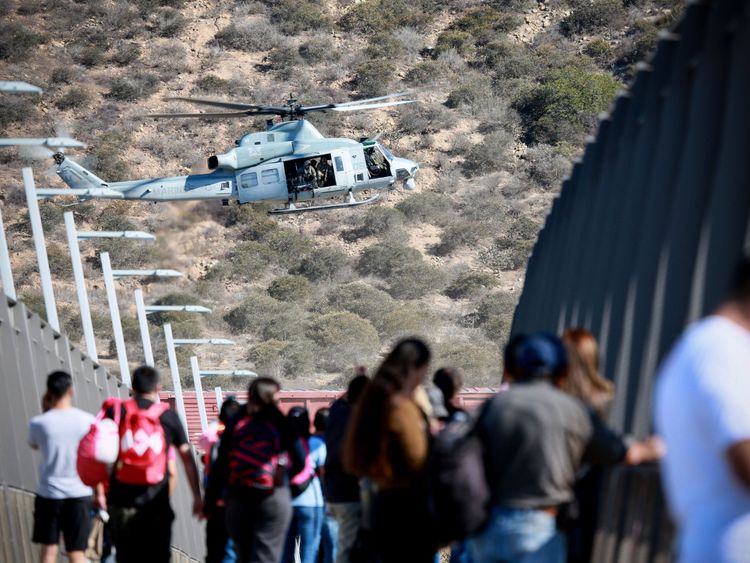 A US military helicopter flies past a pedestrian bridge after the closing of the US-Mexico border