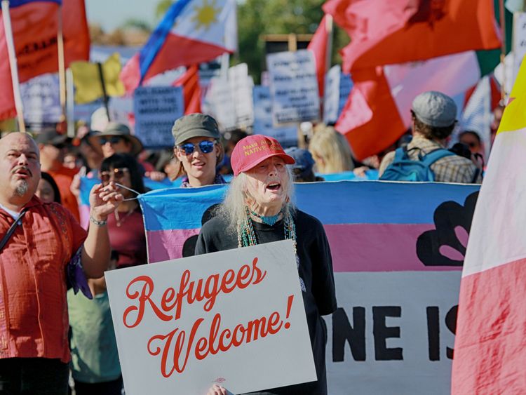 Protesters march along the US-Mexico border to show solidarity with the migrant caravan