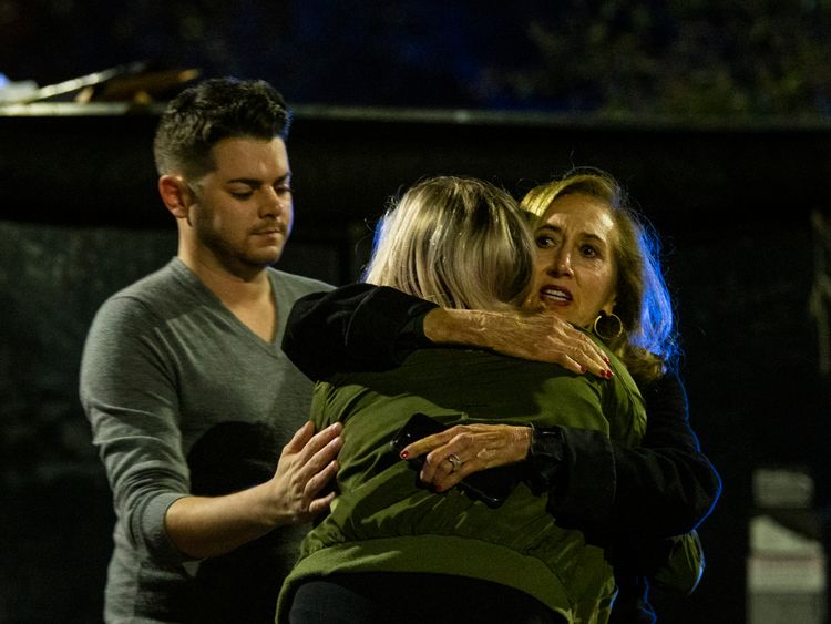 Matthew Rodin, left and Susan Turner comfort Melissa Hutchinson who helped some of the victims of the shooting