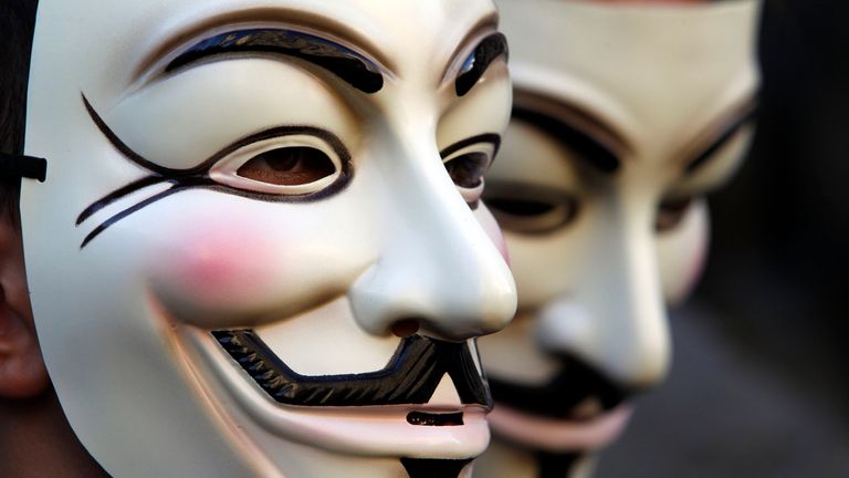 Demonstrators wearing anonymous masks