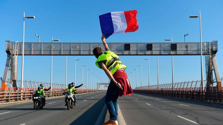  man waves a French flag on the rocade (ring road) during a demonstration of Yellow Vests (Gilets jaunes) against the rising of the fuel and oil prices on November 17, 2018 in Bordeaux, southwestern France