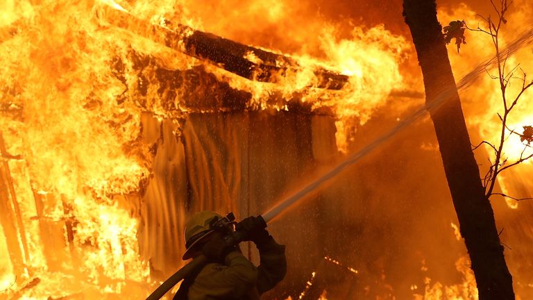 A firefighter battles a wild fire blaze in Magalia, California