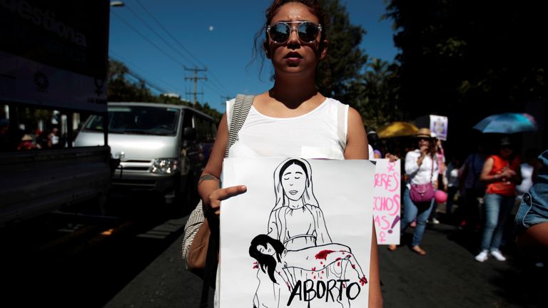 An activist holds a sign reading "Legal Abortion" during a protest in San Salvador