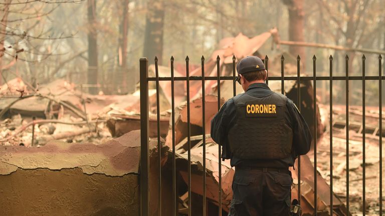 An Alameda County Sheriff Coroner officer looks for human remains at a burned residence in Paradise, California on November 12, 2018. - Thousands of firefighters spent a fifth day digging battle lines to contain California&#39;s worst ever wildfire as the wind-whipped flames cleaved a merciless path through the state&#39;s northern hills, leaving death and devastation in their wake. The Camp Fire -- in the foothills of the Sierra Nevada mountains north of Sacramento -- has killed 29 people, matching the