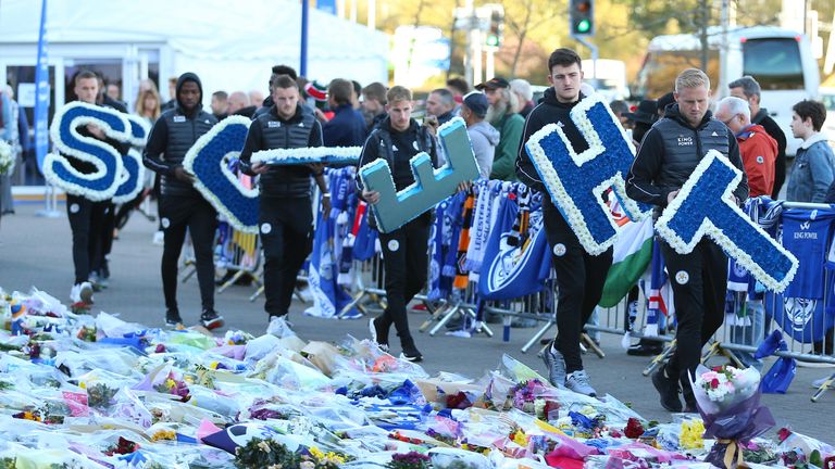 Leicester City players lead by goalkeeper Kasper Schmeichel (right) carry wreaths
