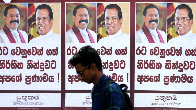 A man walks past a poster of Sri Lanka's newly appointed Prime Minister Mahinda Rajapaksa and President Maithripala Sirisen