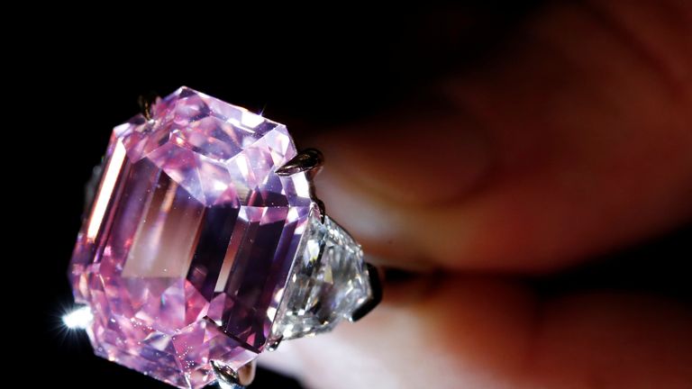 FILE PHOTO: A Christie&#39;s staff holds a 18.96 carat Fancy Vivid Pink Diamond during a preview in Geneva, November 8, 2018. REUTERS/Denis Balibouse/File Photo