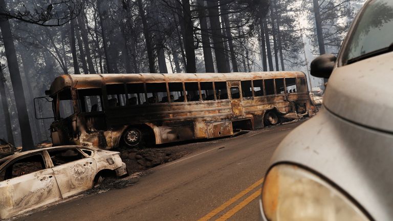 An abandoned and burned school bus is seen on Skyway during the Camp Fire in Paradise