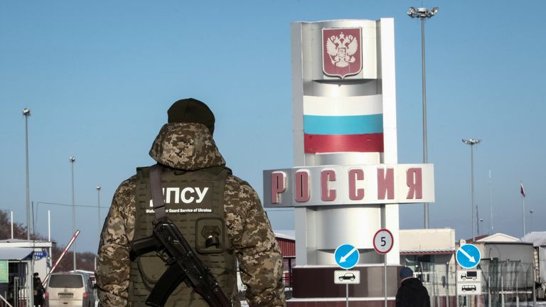 A member of the Ukrainian State Border Guard Service stands guard at the Goptovka crossing point on the border between Russia and Ukraine