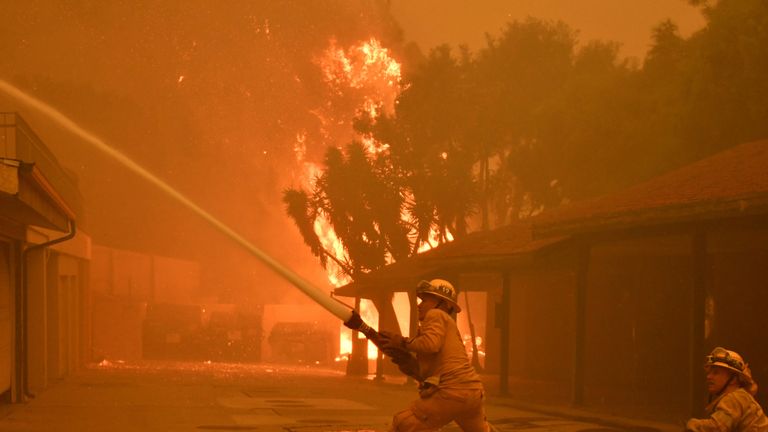 Firefighters hose down a condo unit during the Woolsey Fire in Malibu, California, U.S. November 9, 2018