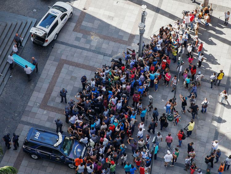 Municipal workers (L) remove the body of one of the victims from the cathedral of Campinas