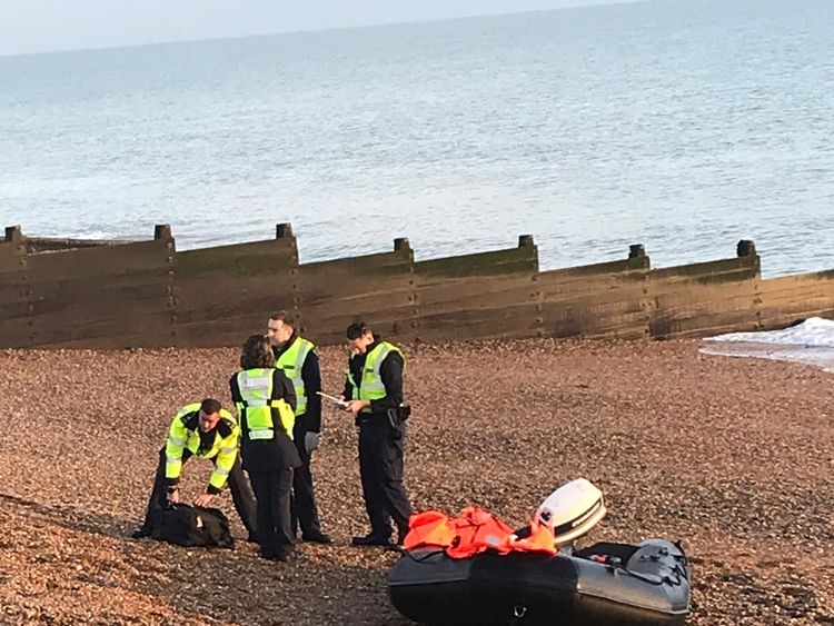 Border officials and an inflatable dinghy on the beach at Kingsdown, Kent