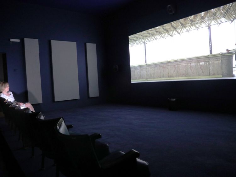  A woman views a video piece by artist Naeem Mohaiemen at Tate Britain