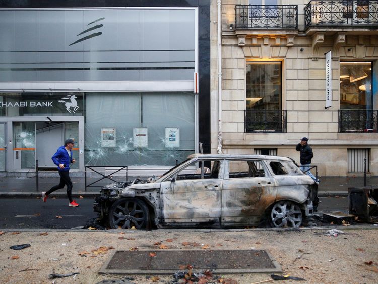 A vandalized car and bank front are seen the morning after clashes with protesters wearing yellow vests, a symbol of a French drivers' protest against higher diesel fuel taxes, in Paris, France, December 2, 2018.