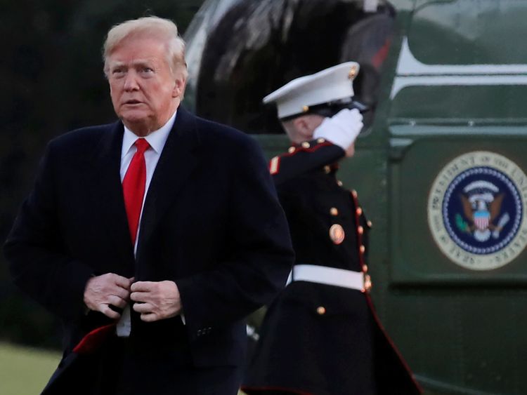 President Donald Trump steps off Marine One and walks across the South Lawn after returning to the White House