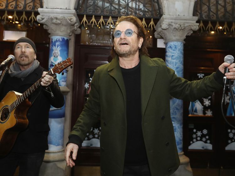 U2's The Edge and Bono take part in the annual Christmas Eve busk on Grafton Street, Dublin