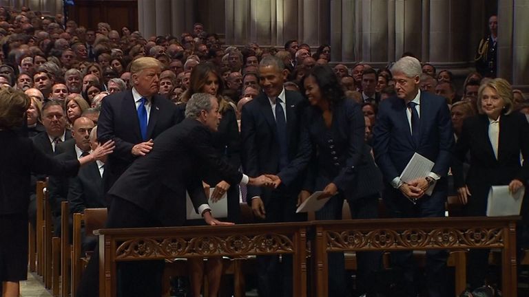 George W Bush slips Michelle Obama a piece of candy as a kind gesture at the state funeral for his father, George HW Bush.