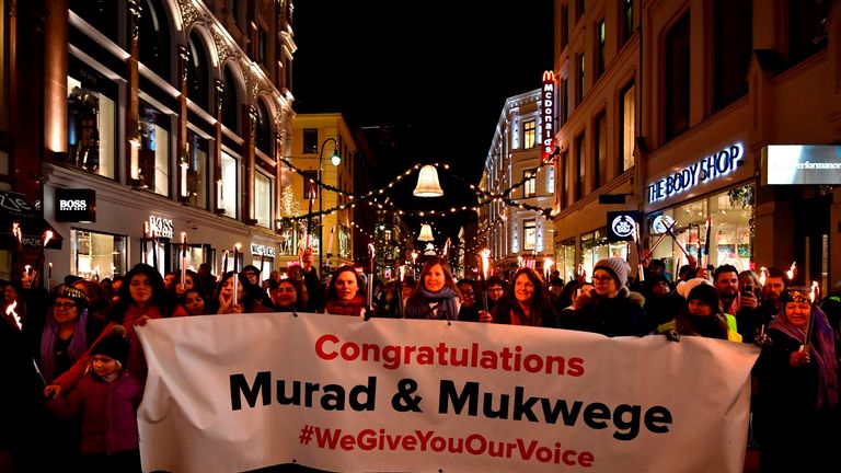 People walk in the streets of Oslo, Norway, holding candles during a torchlight procession to greet Nobel prize laureates Congolese gynaecologist Denis Mukwege and Iraqi Yazidi-Kurdish human rights activist Nadia Murad on December 10, 2018