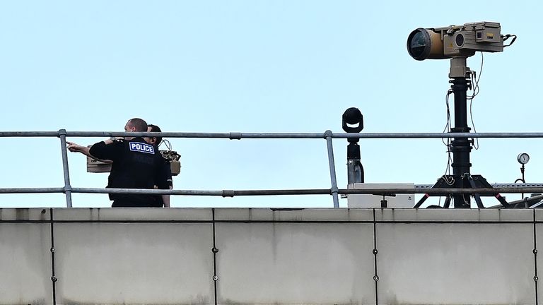 Police officers stand near equipment on the rooftop of a building at London Gatwick Airport, south of London, on December 21, 2018, as flights resumed following the closing of the airfield due to a drones flying. - British police were Friday considering shooting down the drone that has grounded flights and caused chaos at London&#39;s Gatwick Airport, with passengers set to face a third day of disruption. Police said it was a &#39;tactical option&#39; after more than 50 sightings of the device near the airf