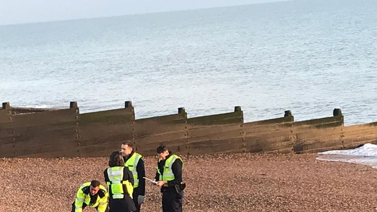 Border officials and an inflatable dinghy on the beach at Kingsdown, Kent