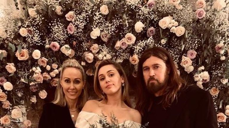 Miley Cyrus (C) with parents Tish and Billy Ray Cyrus on her wedding day