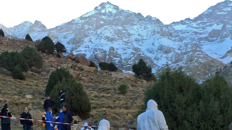 Police officers work next to a tent where the bodies of two Scandinavian women were found